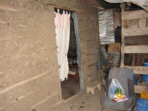 Stone house with a cloth separating the rooms with a chair on the ground