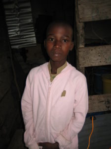 Ibrahim Miraji Idd standing indoors with a pallet in the background