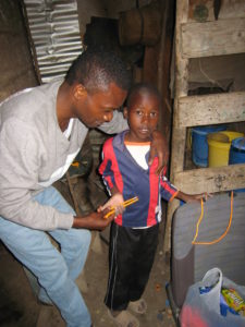 Shimba embracing Abdulsalam who is holding pencils