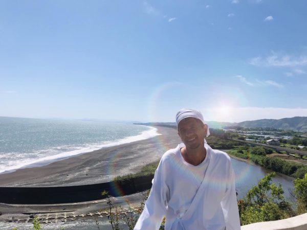 Sergiu Kondanna in front of sea with a lens flare effect